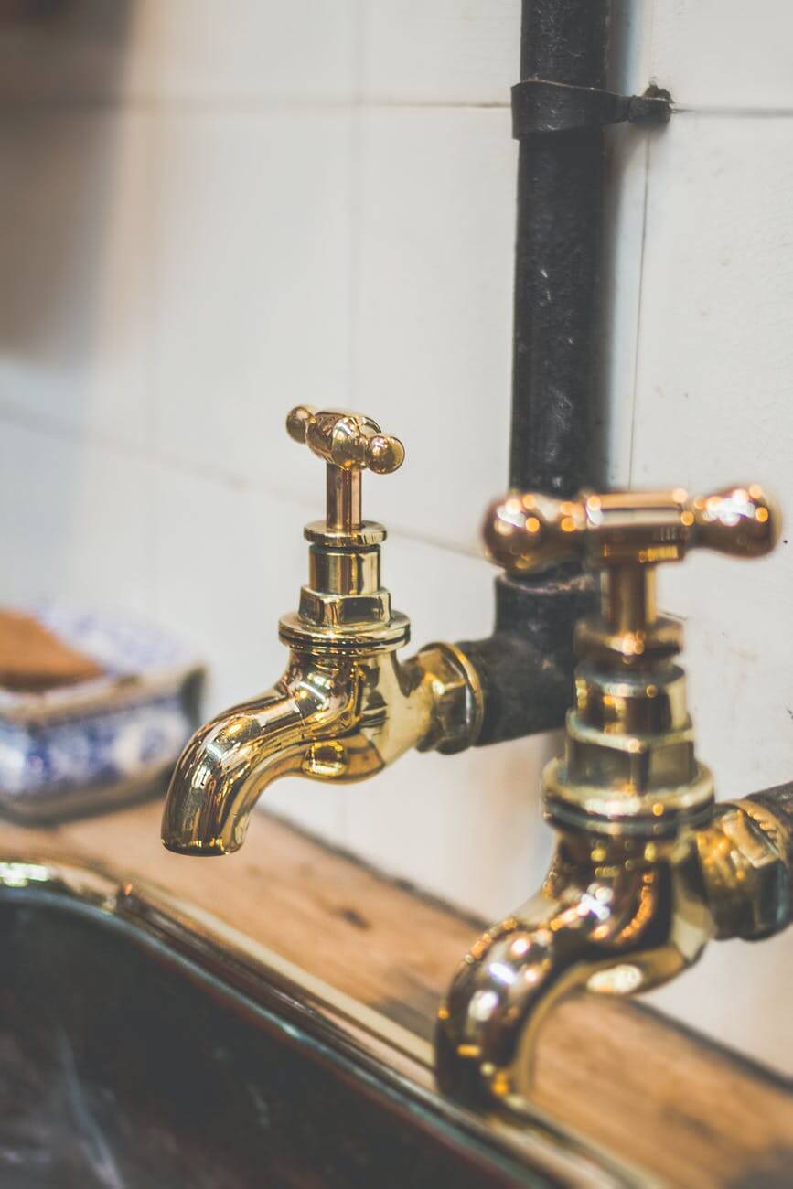 shallow focus photography of gold faucets