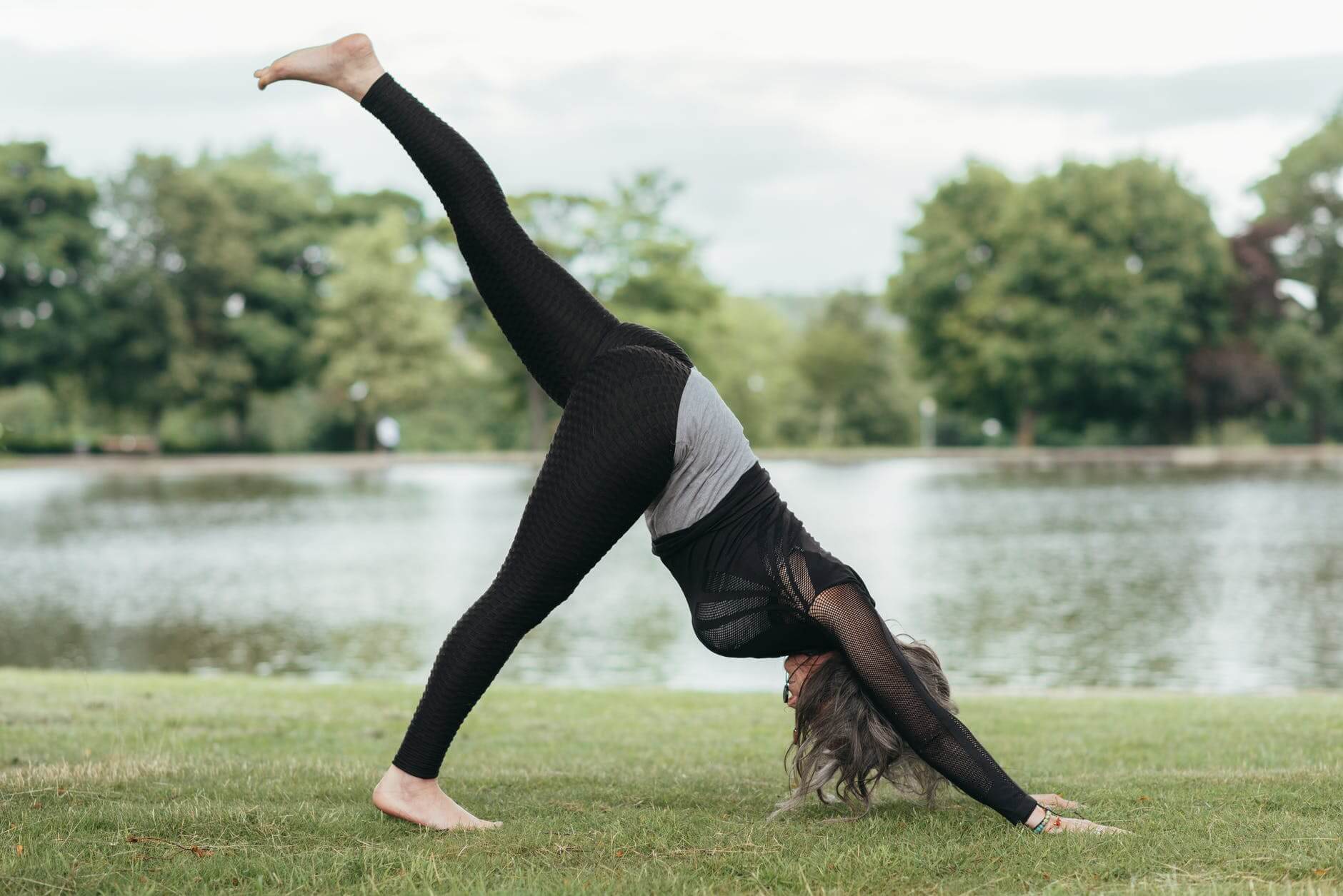 unrecognizable woman showing three legged downward facing dog pose
