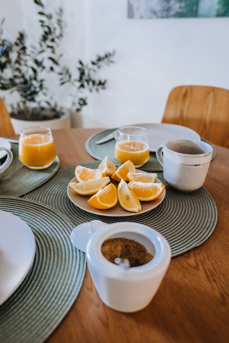 served breakfast with teacups and orange juice in glassware