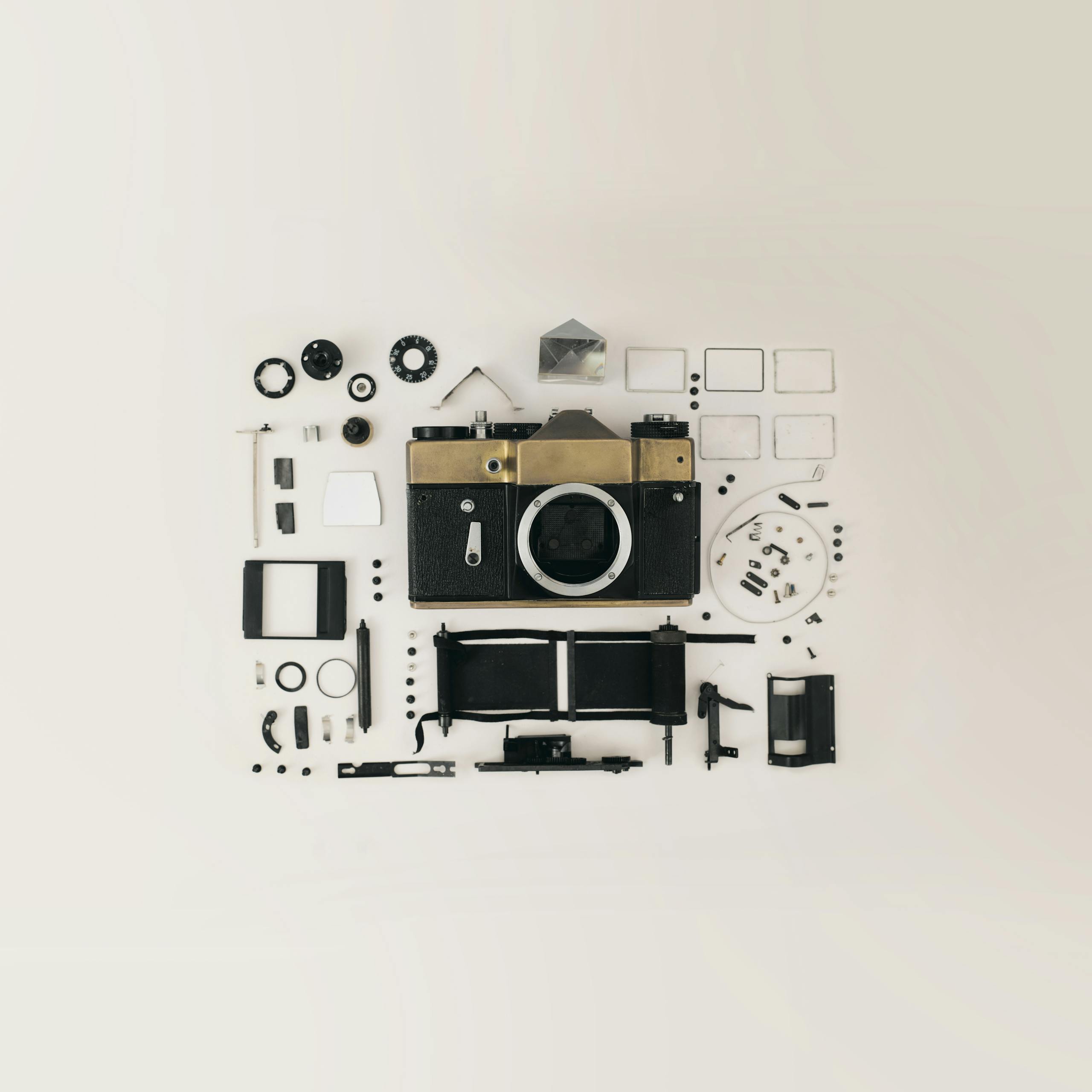 Flat lay of disassembled vintage camera parts showcasing intricate components and design.