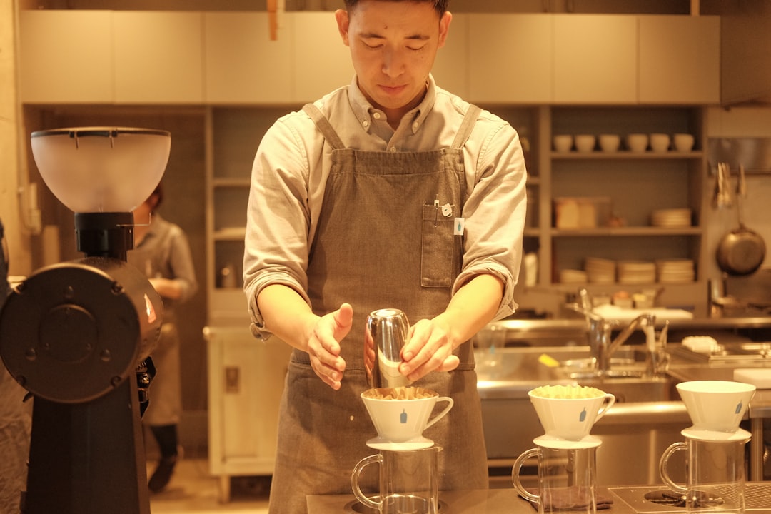 a man in a kitchen preparing food in a blender