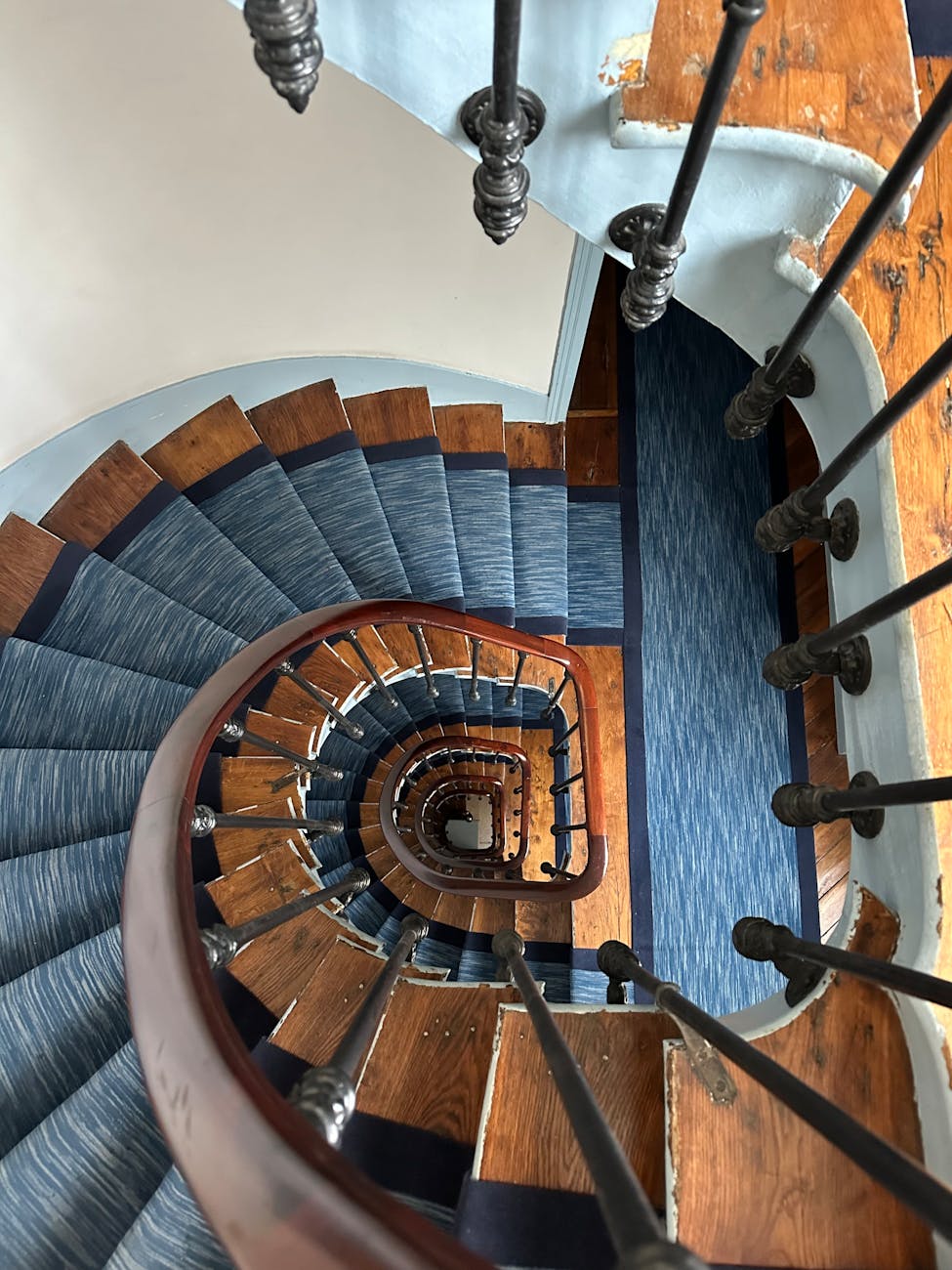 spiral wooden staircase with blue carpet