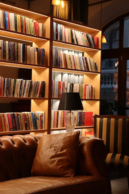 Built-in illuminated bookshelf alcove behind leather sofa creating cozy study nook in home library