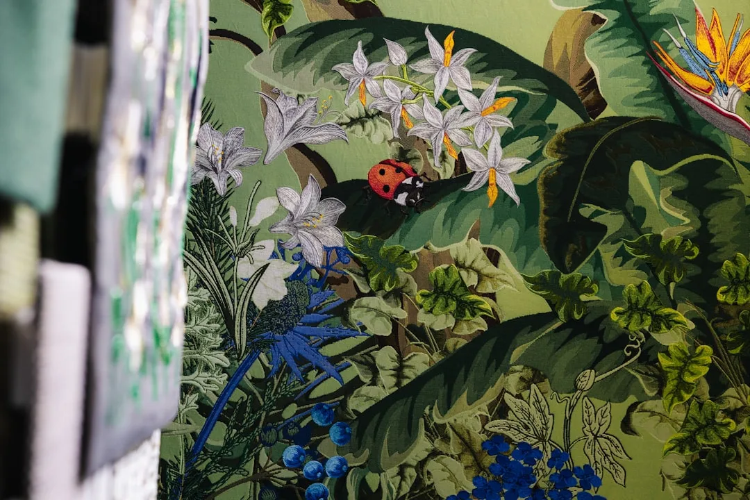 Oversized botanical fabric print with tropical leaves, white flowers, ladybug, and bird of paradise in lush green design