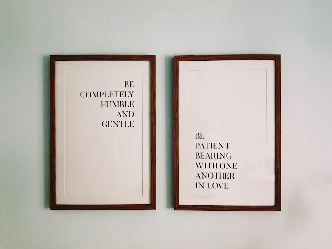 Two framed prints on wall with inspirational quotes about humility and patience as unifying principles