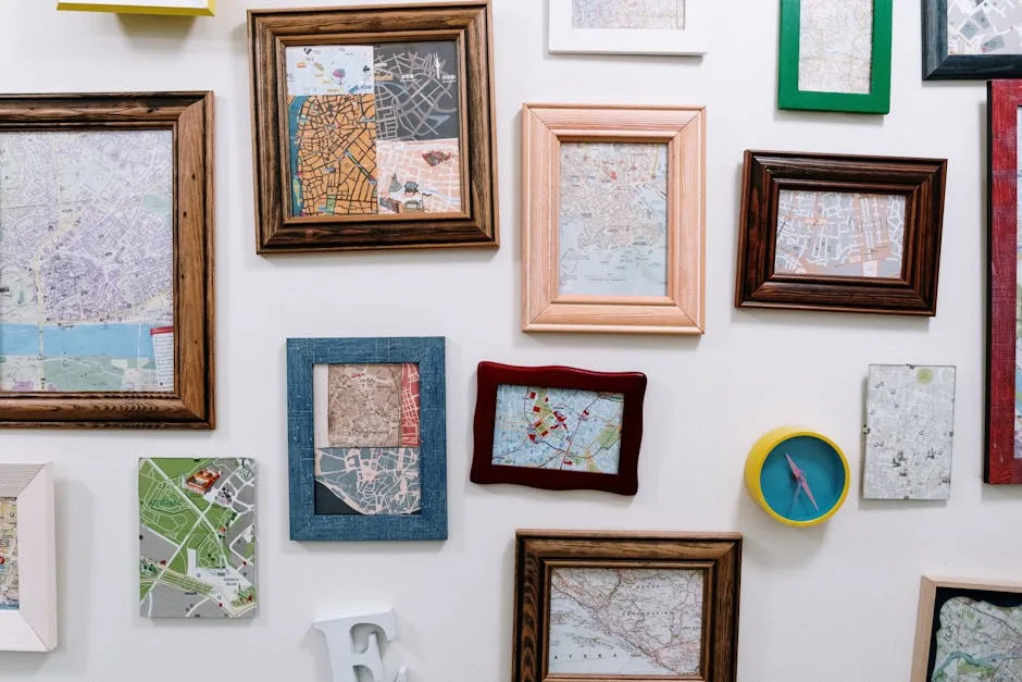 Collection of framed city maps arranged on a white wall with a decorative compass, showcasing gallery wall layout