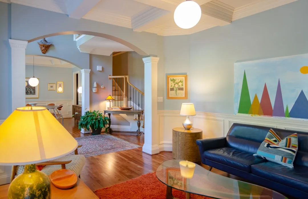 Living room with layered lighting including globe pendant, table lamps, and ambient lighting creating warm inviting atmo