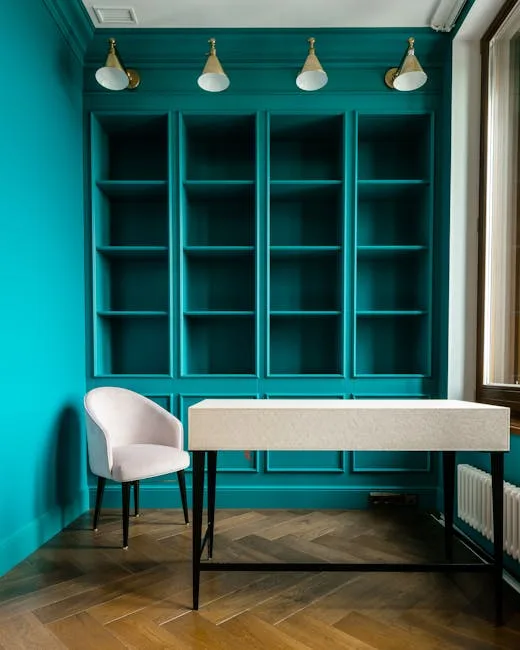 Built-in teal bookshelves with white desk and pink chair in a compact home office space