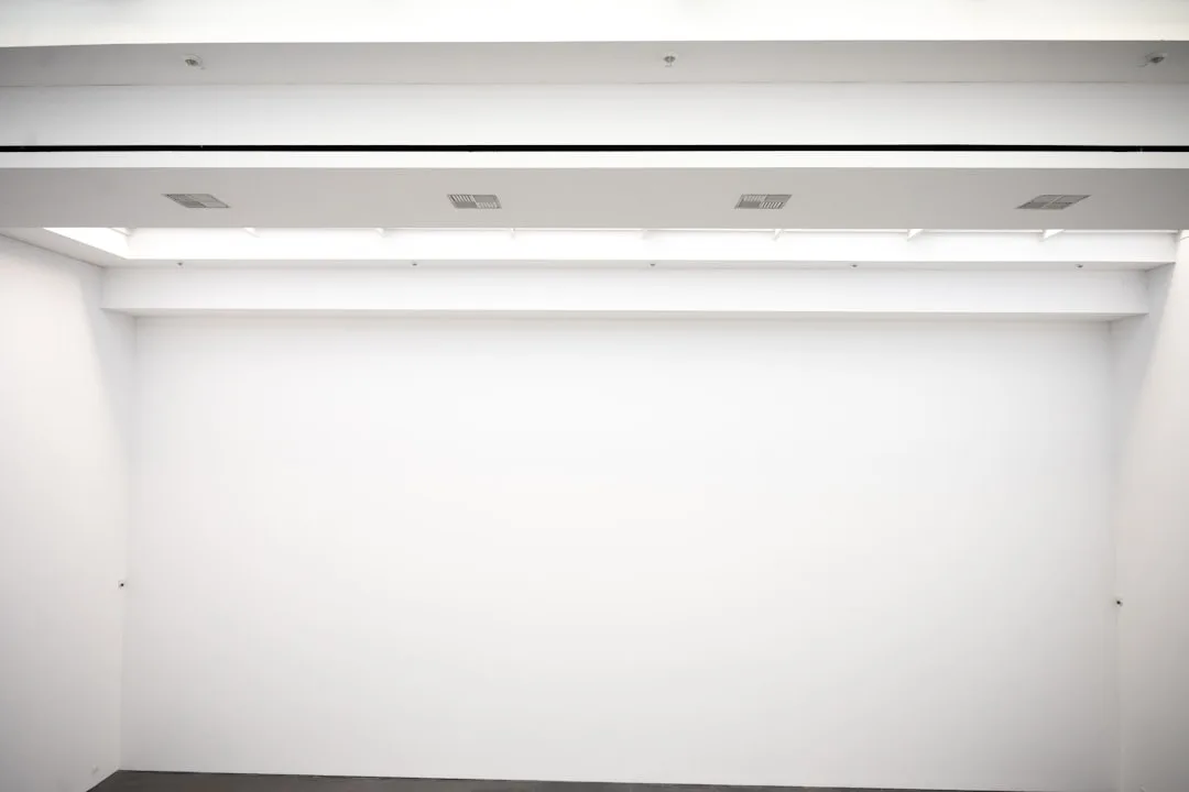 White ceiling with HVAC ventilation grilles and recessed lighting in a modern interior space
