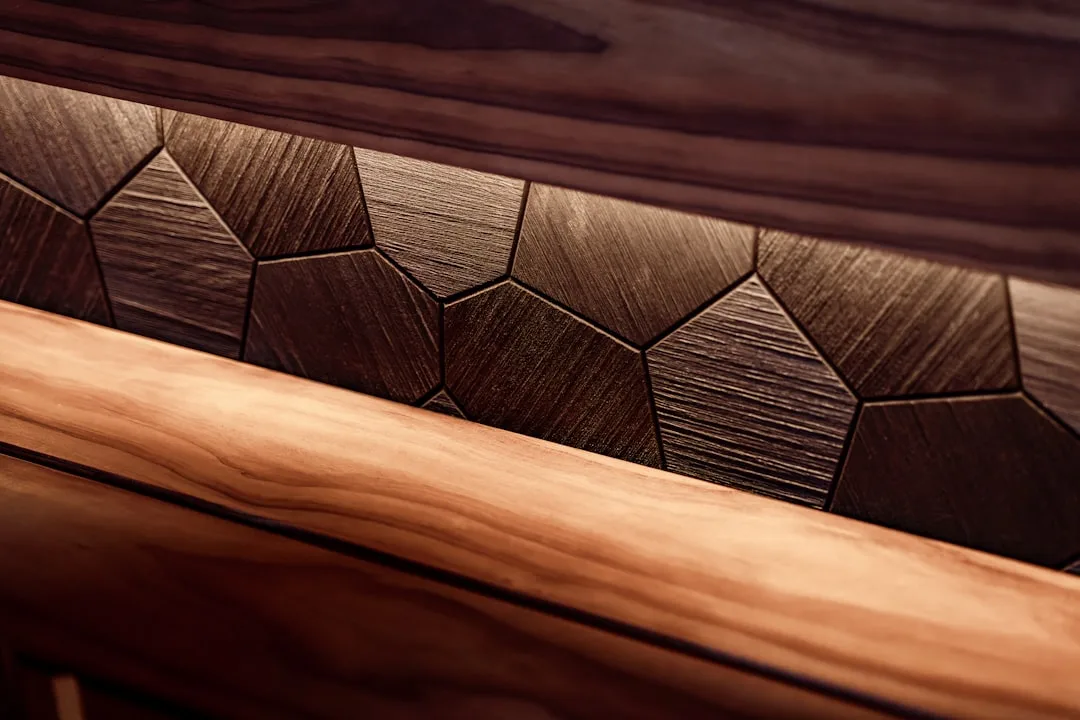 Close-up of handcrafted wood furniture with geometric Voronoi pattern inlay showing visible grain texture and craft mark