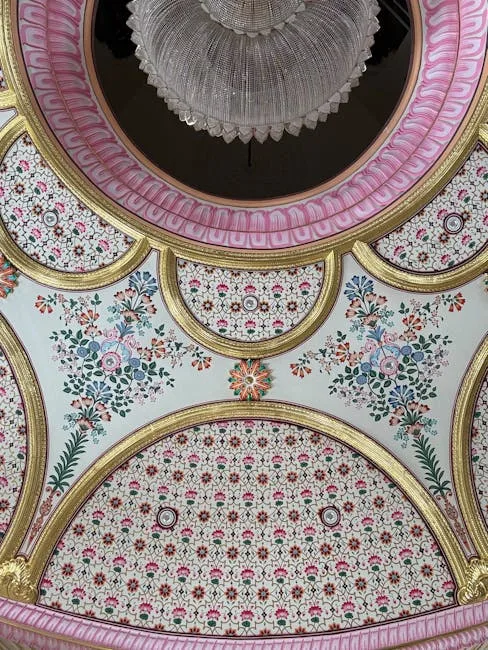 Ornate ceiling with small-scale ditsy floral pattern in pink and gold arched moldings with crystal chandelier
