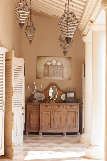Elegant entryway with antique wooden sideboard, Moroccan pendant lights, and decorative mirror in warm Mediterranean vil