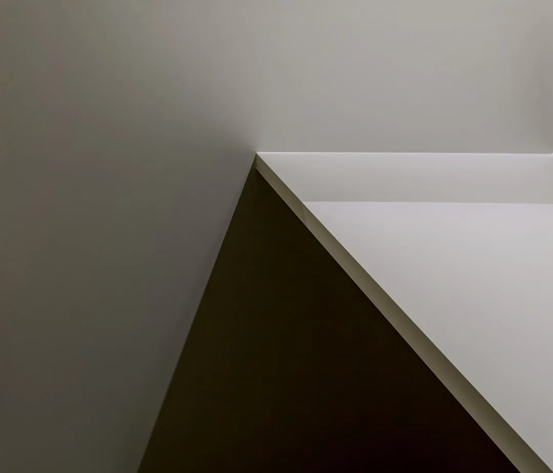 Architectural diagonal corner detail showing triangular geometric lines and shadow contrast in minimalist interior desig