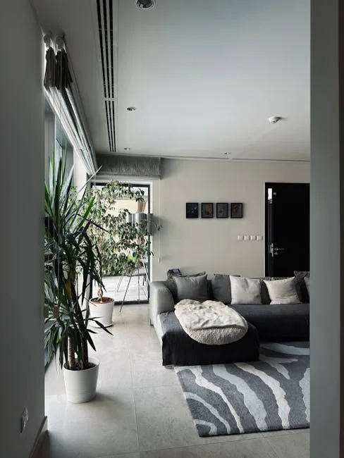 Gray sectional sofa with abstract patterned rug defining seating zone in modern small living room