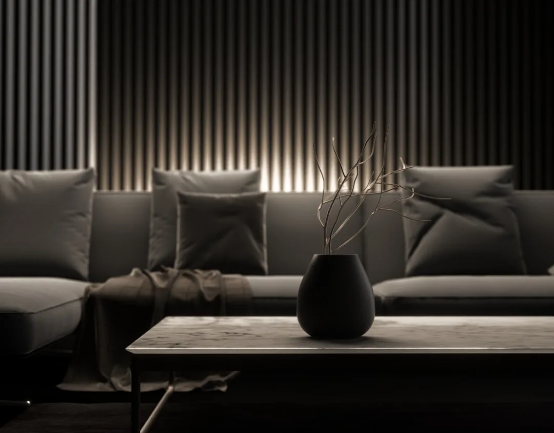 Minimalist dark living room with single black vase on marble coffee table demonstrating restraint in luxury interior des