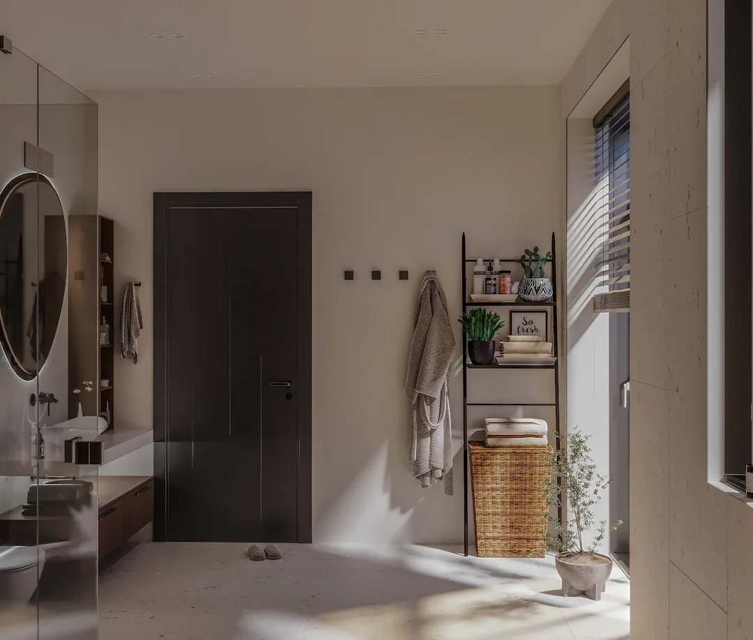 Modern bathroom with ladder shelf storage, wicker basket, wall hooks, and round mirror in neutral tones