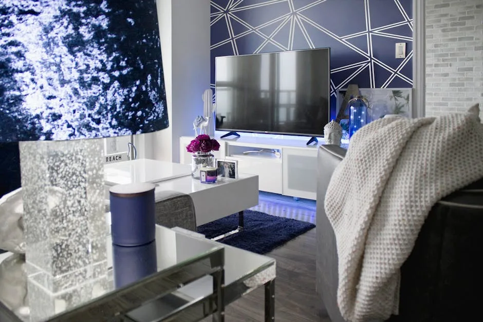 Modern living room with white TV console, navy accent wall, geometric pattern, coffee table and cozy throw blanket