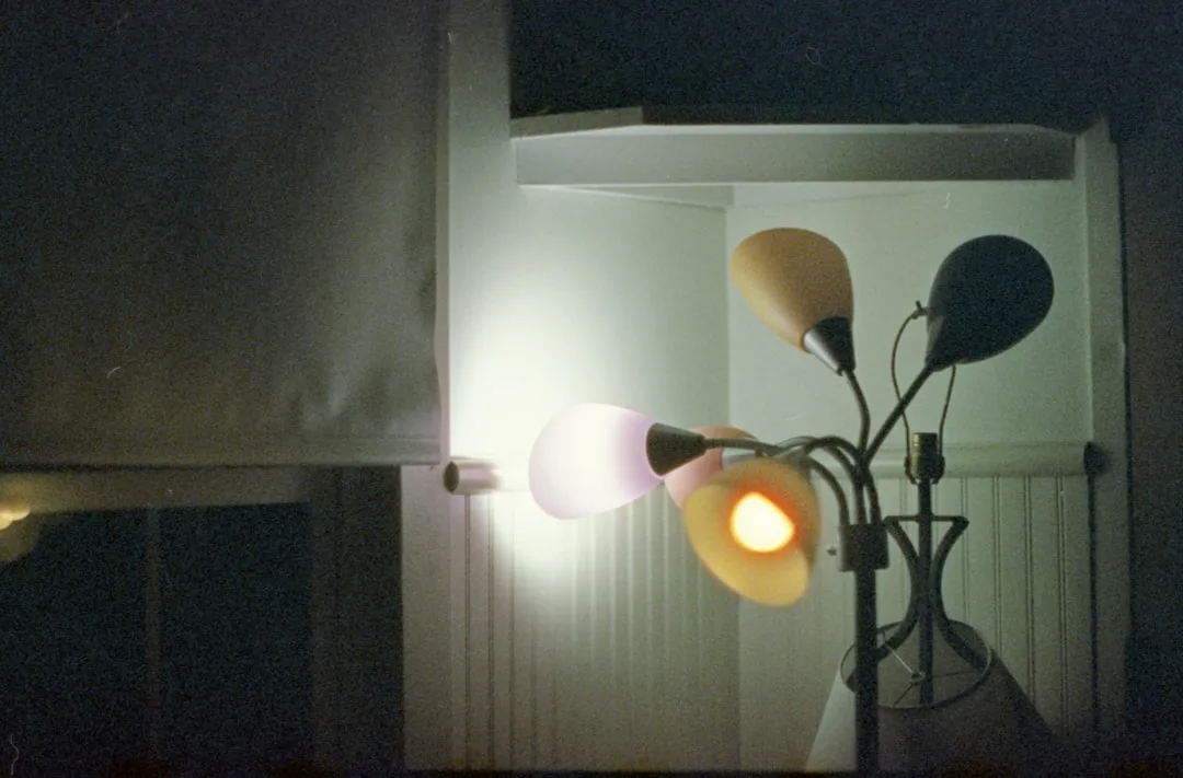 Vintage multi-arm floor lamp with glowing bulbs in dark room showing accent lighting effect
