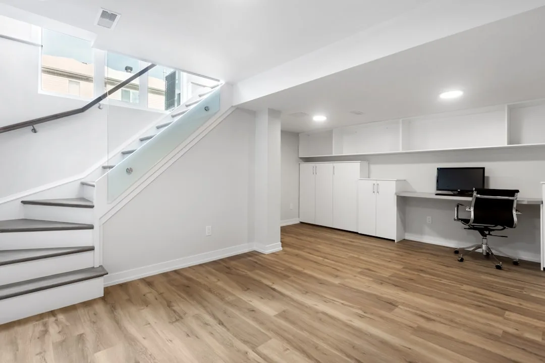 Finished basement with hardwood floors, white buil