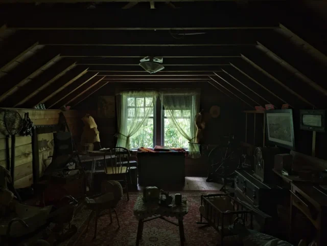 Dark cluttered attic space with sloped wooden beam