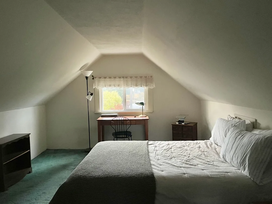 Converted attic bedroom with sloped ceiling, bed,