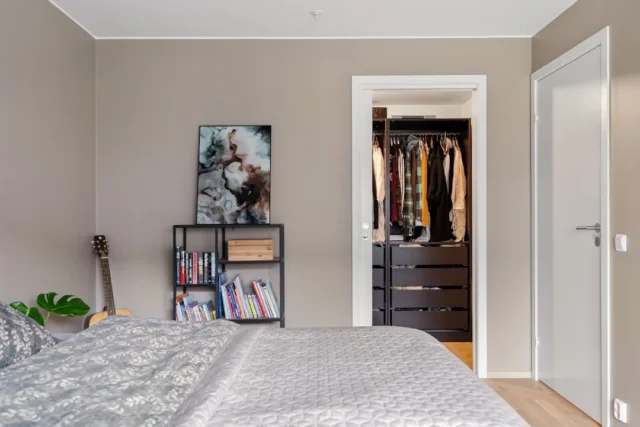 Bedroom with open walk-in closet showing hanging c