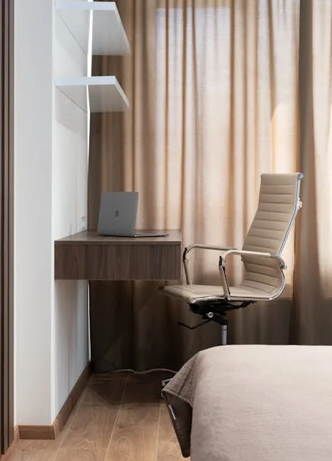 Floating walnut corner desk with laptop and ergonomic office chair in a minimalist bedroom workspace setup