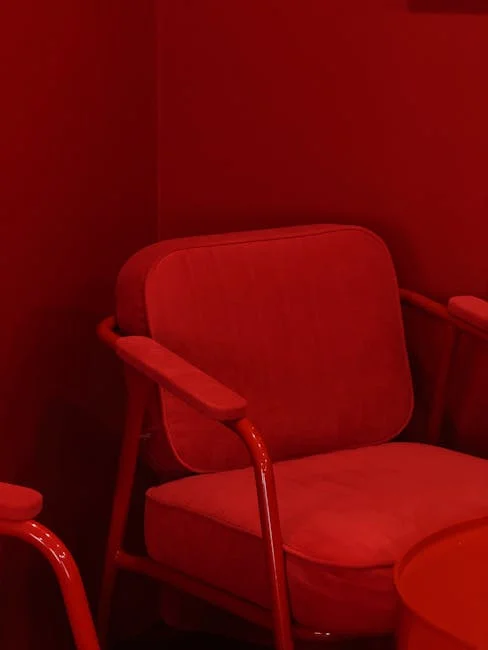 Bold red upholstered armchair in monochromatic red room – 2026 sofa color trend