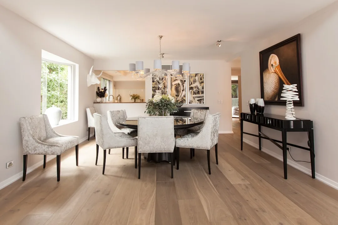 Elegant dining room with round black table, velvet chairs, and hardwood floors in a 10x10 dedicated dining space