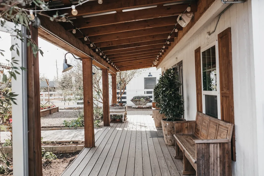 Farmhouse porch with warm 2700K Edison string lights strung across wooden ceiling beams