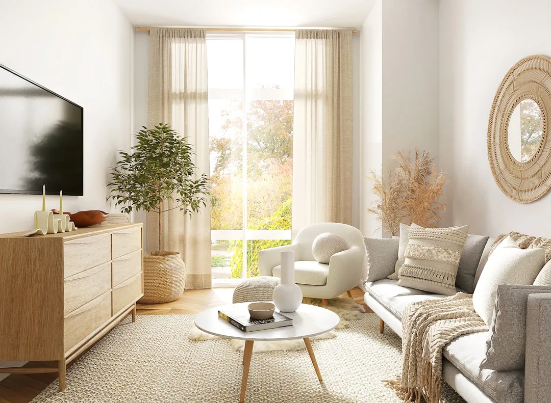 Budget-friendly Scandinavian living room with natural wood dresser, white bouclé chair, and neutral boho decor accents