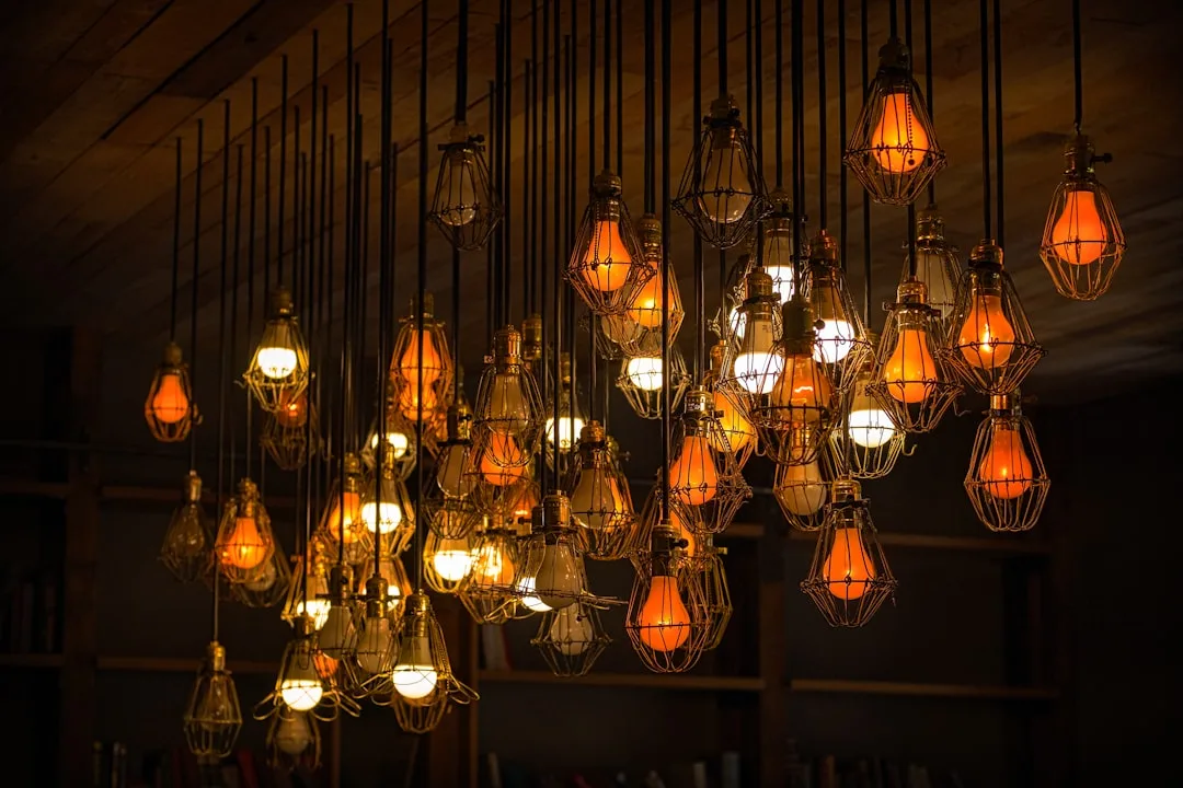 Industrial cage pendant lights with warm Edison bulbs hanging from wooden ceiling in dark rustic interior
