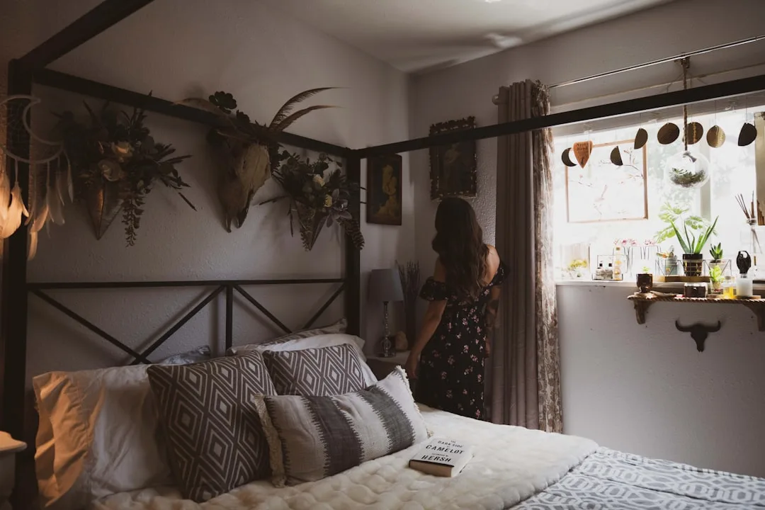Boho bedroom makeover with four-poster bed, patterned pillows, wall decor, and window shelf under $100