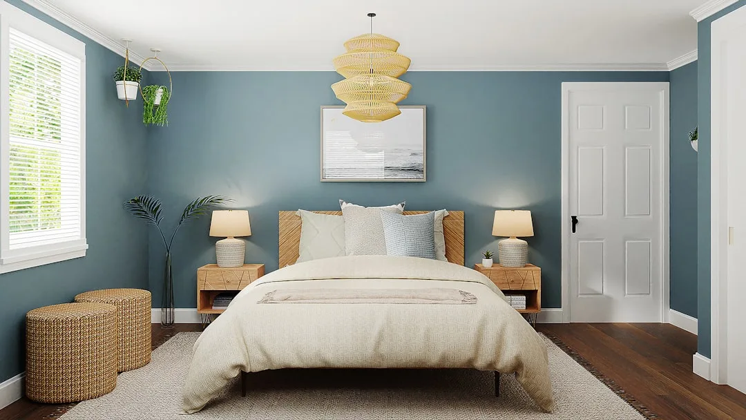 Calming blue-green bedroom with neutral bedding, rattan pendant light, and warm wood accents for better sleep