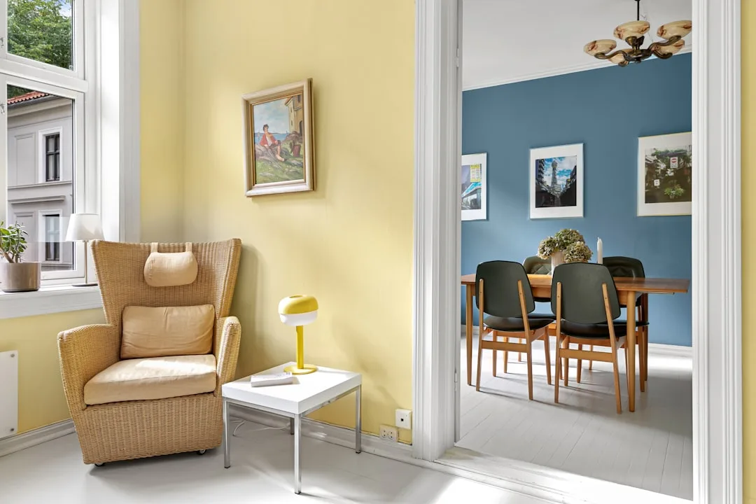 Yellow sunlit sitting room and blue dining room showing how natural light affects wall paint color perception
