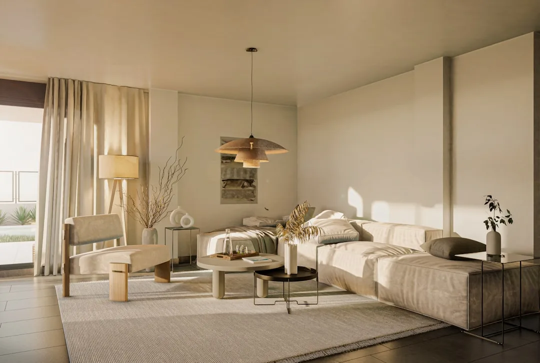 Minimalist living room with neutral beige tones, low-profile sofa, rattan pendant light, and natural wood accents