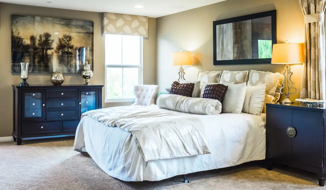 Spacious master bedroom with king-size bed, dark wood dresser, and nightstands showing room layout and furniture spacing