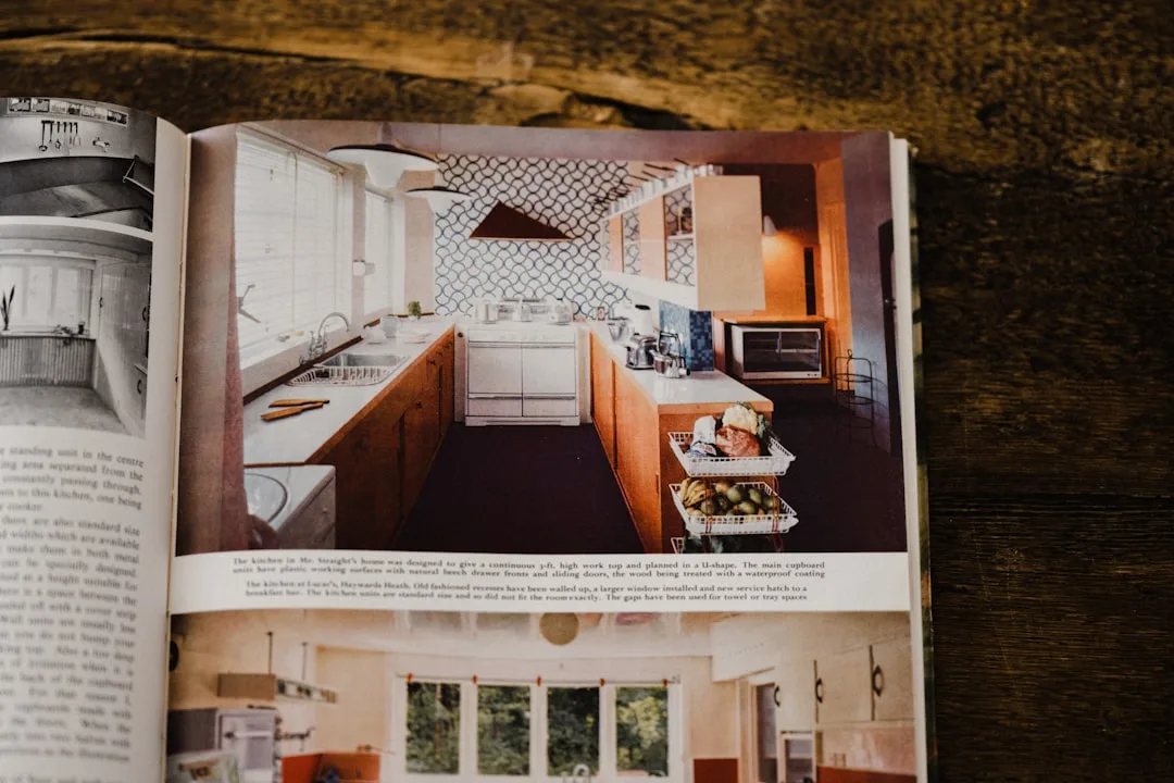 Vintage kitchen design magazine spread showing U-shaped kitchen layout with wood cabinets and patterned backsplash