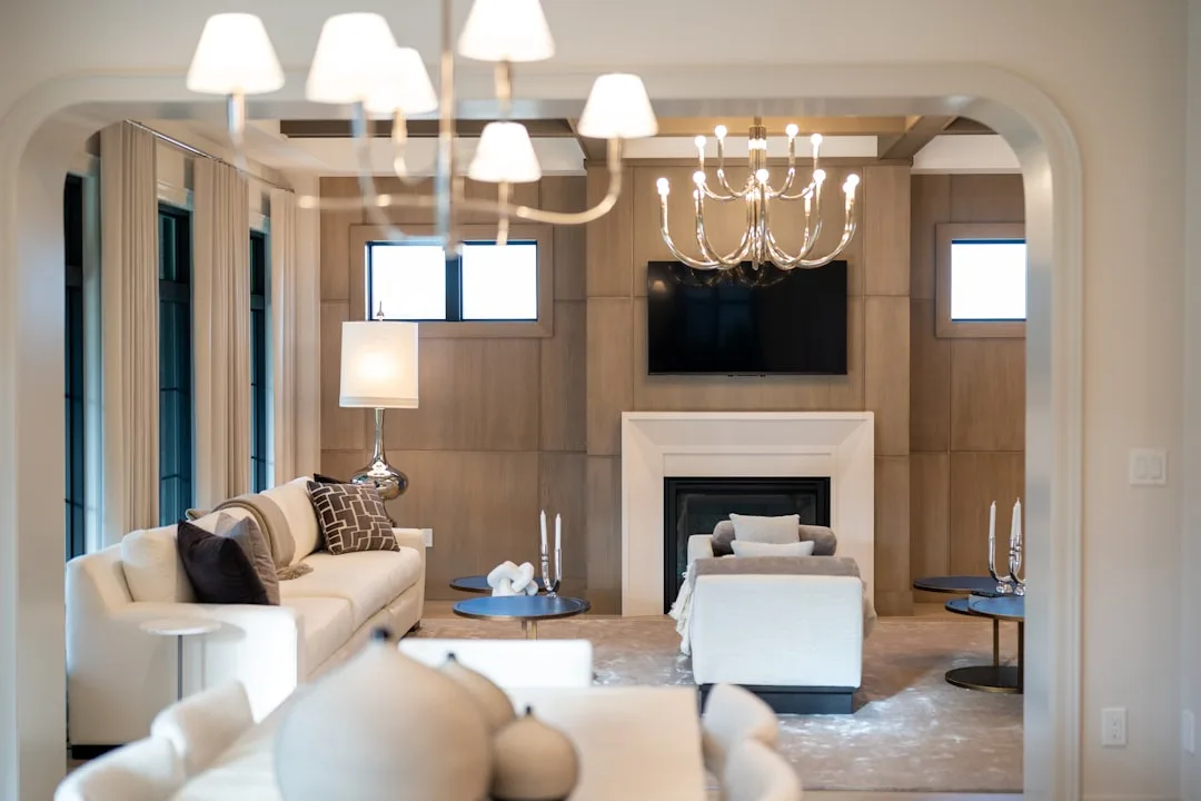 Layered accent lighting in luxury living room with chandelier, table lamp, and fireplace creating warm ambiance