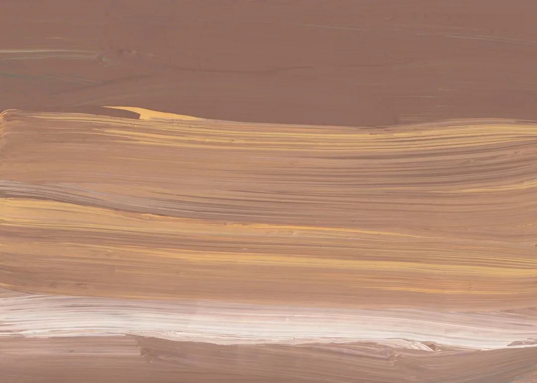Layered chocolate brown paint strokes blending warm golden yellow and soft white tones on textured surface