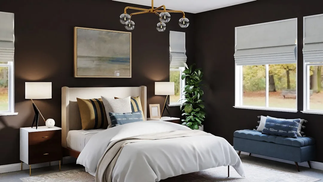 Luxury dark-walled bedroom with gold chandelier, tufted headboard, layered pillows, blue bench, and fiddle leaf fig plan