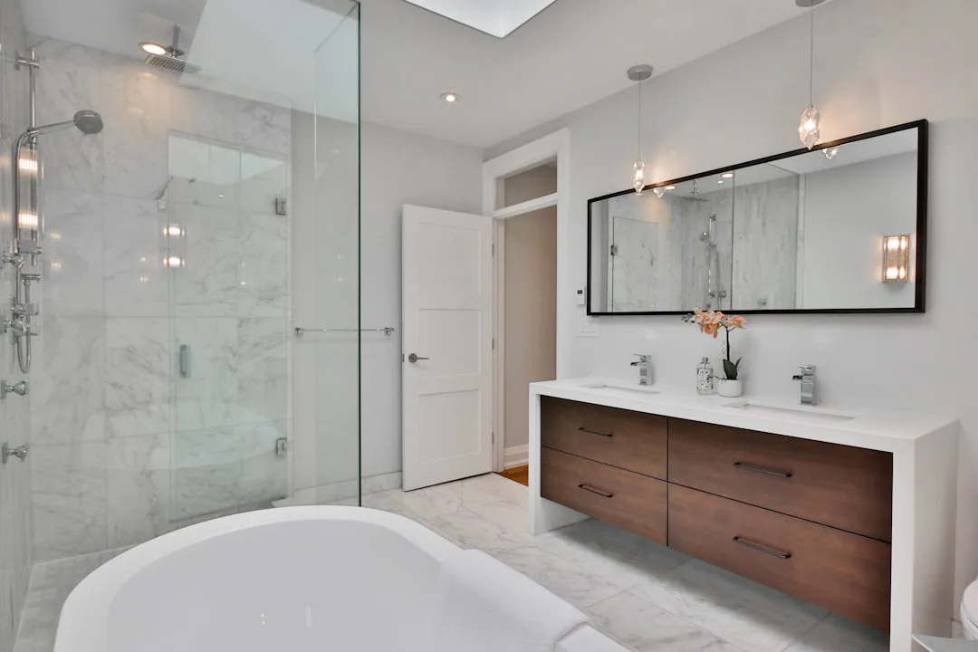 Luxury bathroom remodel with marble shower, freestanding tub, floating wood vanity and double sinks