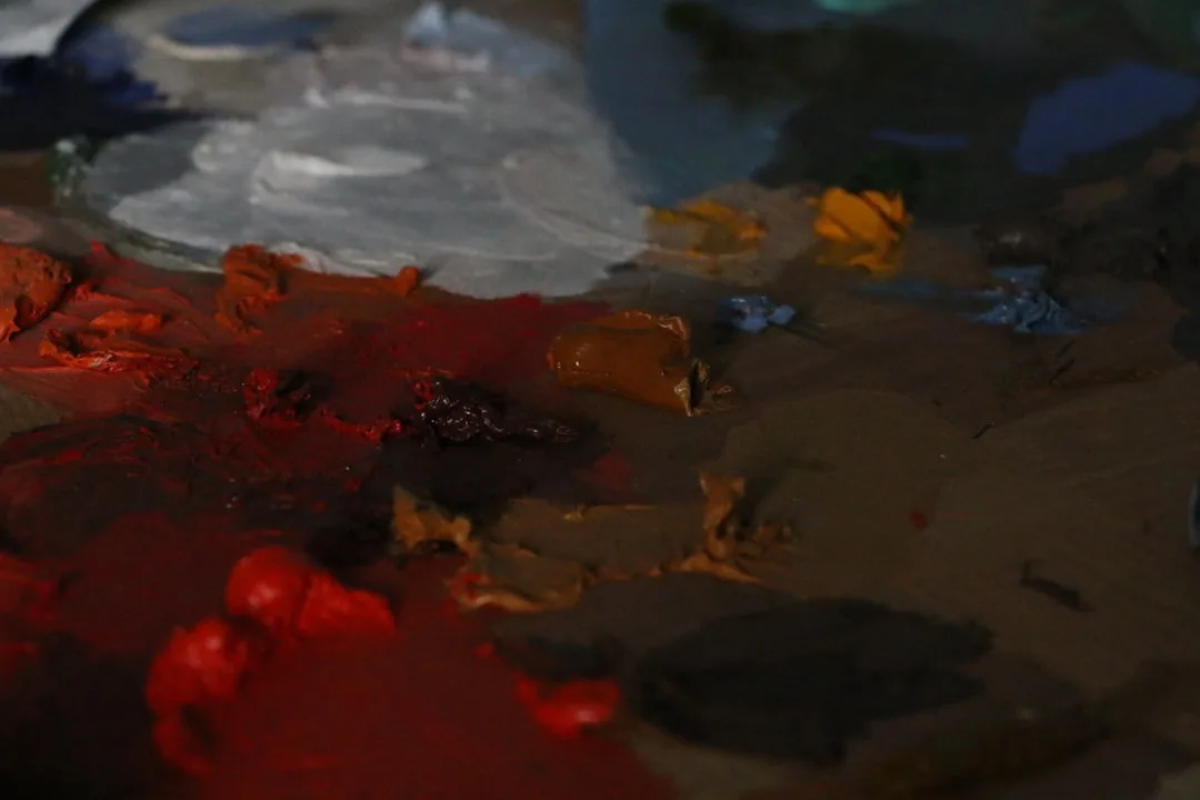Artist paint palette with warm reds and cool blues showing how light temperature affects color perception in interior de