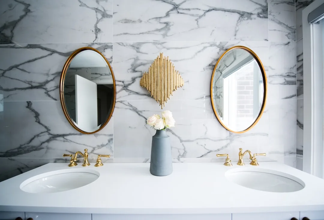 Luxury bathroom remodel with marble walls, gold fa
