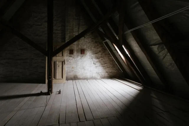Empty unfinished attic space with wooden floors an