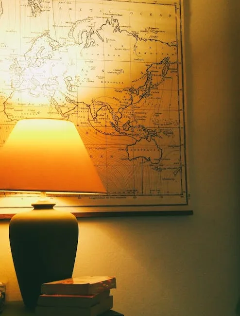 Warm glowing table lamp casting light on a vintage world map in a cozy apartment reading nook