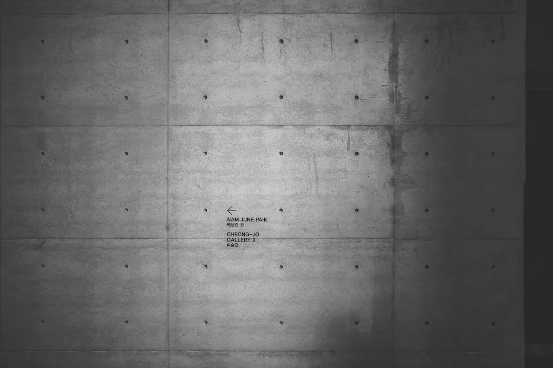 Exposed concrete wall with grid panel pattern and bolt holes at Nam June Paik gallery, Cheong-Jo museum