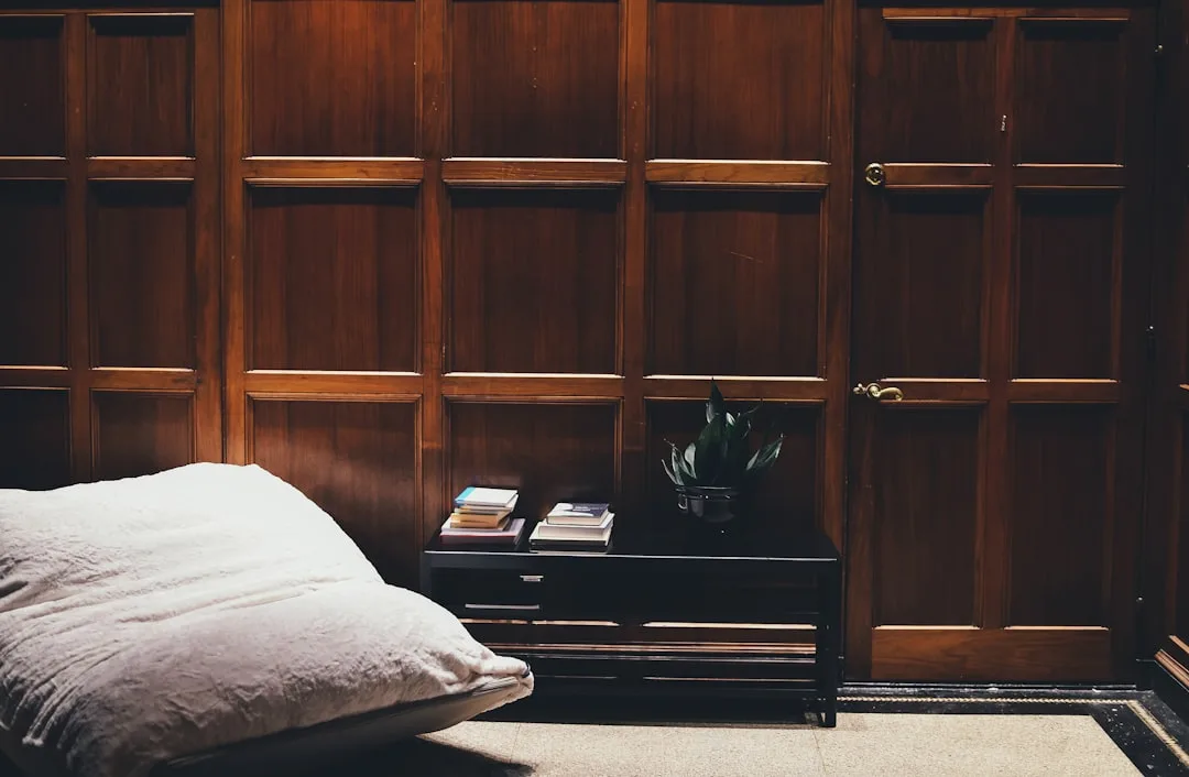 Bedroom with bed and nightstand pulled away from w