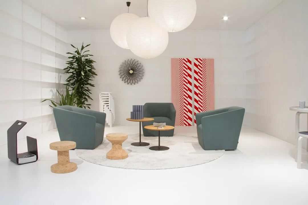 Modern living room seating arrangement with three teal armchairs on circular rug demonstrating ideal conversation diamet