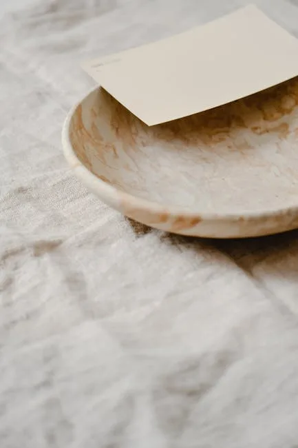 Marble plate with cream paint swatch on linen fabric showing warm neutral tones for Japandi interior design